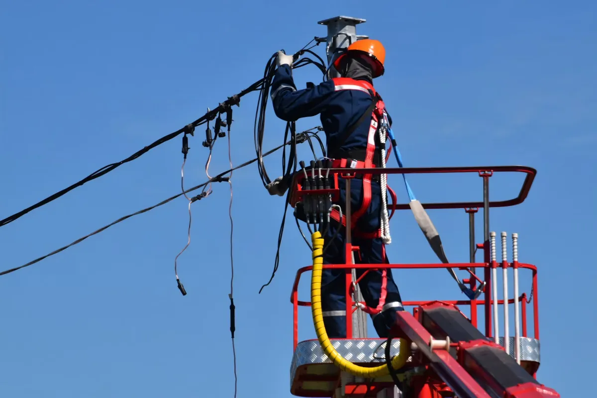 Technicien intervenant sur une ligne de distribution d'électricité