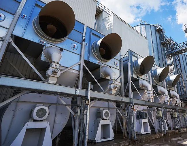 Équipements techniques de ventilation installés sur un bâtiment industriel
